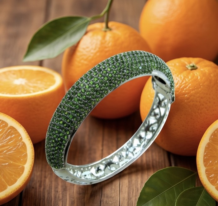 Authentic 10.9 carat pave Chrome Diopside .925 Sterling Silver dipped in Rhodium handcrafted Bracelet - Chrome Diopside bangle with oranges; top view on wood surface.