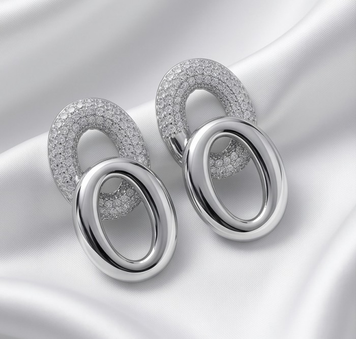 TIFFANY - LUXURIUS - Natural pave White Topaz rhodium over .925 Sterling Silver handmade earrings - Close-up of oval earrings with pave white topaz on satin background.