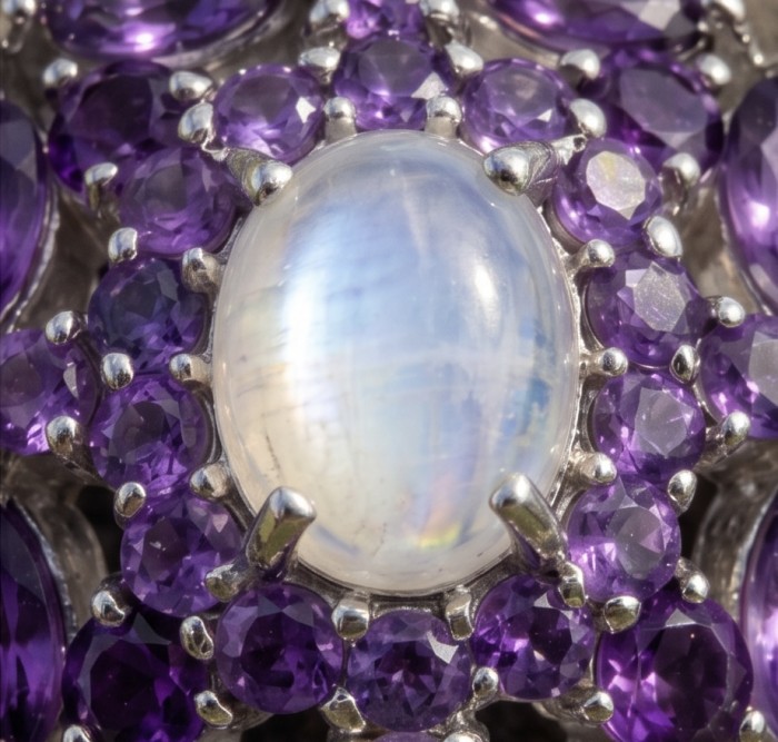 Genuine 5.2 carat Pink Fire Moonstone .925 Sterling Silver handcrafted pendant - Stone close-up of moonstone with purple gems in silver setting.