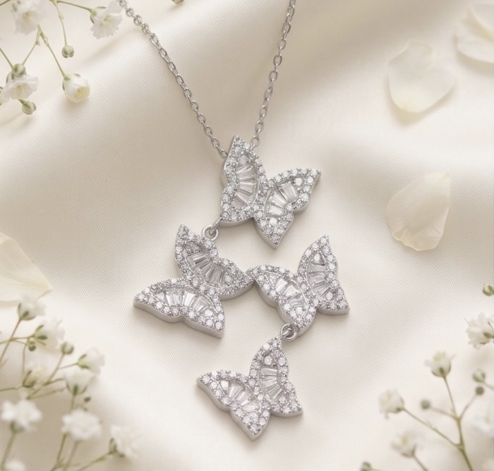 Four Butterflies natural 7.5 carat White Topaz .925 Sterling Silver handmade Statement necklace - Butterfly necklace with white topaz on silk background, top view.