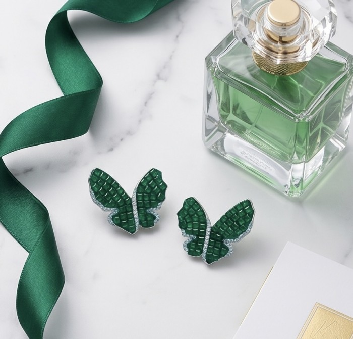 Incredible Butterflies genuine 15.5 CARAT Emerald .925 Sterling Silver handcrafted Earrings - Emerald butterfly earrings with perfume bottle and green ribbon on marble surface.