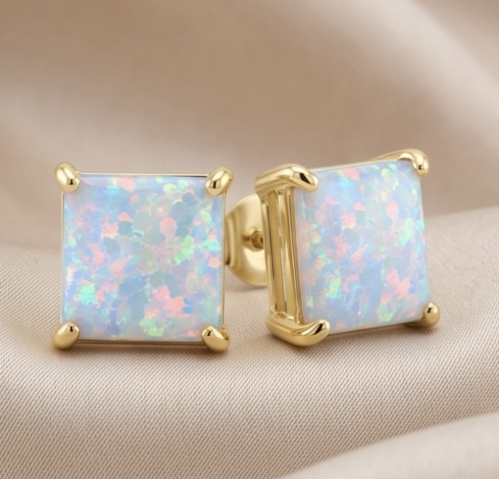 2.2 carat Australian Blue Opal 14K Gold over .925 Sterling Silver incredible handcrafted Earrings - Square opal studs in gold setting on fabric background, close-up view.