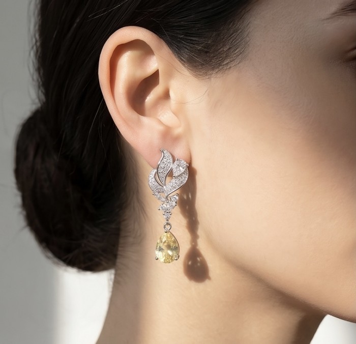 Luxurious 4.5 carat Golden - yellow Montana Sapphire .925 Sterling Silver handcrafted earrings - Side view of earring with golden-yellow sapphire and diamonds worn on ear.
