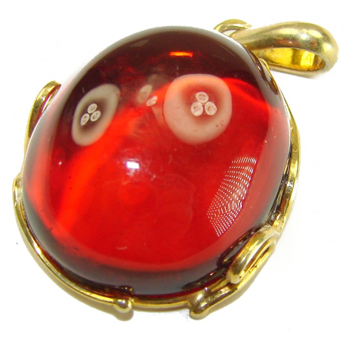 Prehistoric Authentic Baltic Amber .925 Sterling Silver dippedin 14K Gold beautifully handcrafted Pendant - Close-up of red amber pendant with a gold-toned clasp detail
