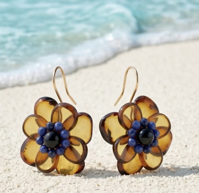 Summer Flowers Wonderful natural Baltic Amber 14K Gold over .925 Sterling Silver entirely handcrafted earrings - Amber flower earrings on sand with ocean background, front view.
