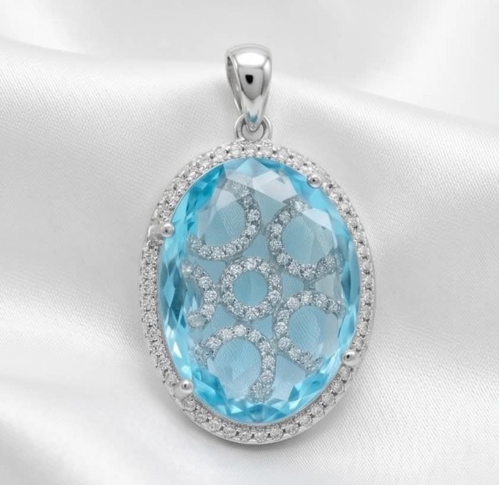 Angelina 14.9 carat authentic Aquamarine .925 Sterling Silver Handcrafted pendant - Close-up of oval aquamarine pendant with silver detailing on white fabric