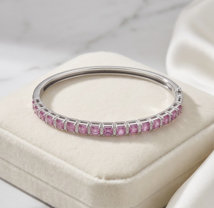 Art Deco Giovanna 7.2 carat Mozambique Ruby .925 Sterling Silver dipped in rhodium Statement Bracelet - Side view of Art Deco Giovanna Ruby Bangle on cream display cushion.