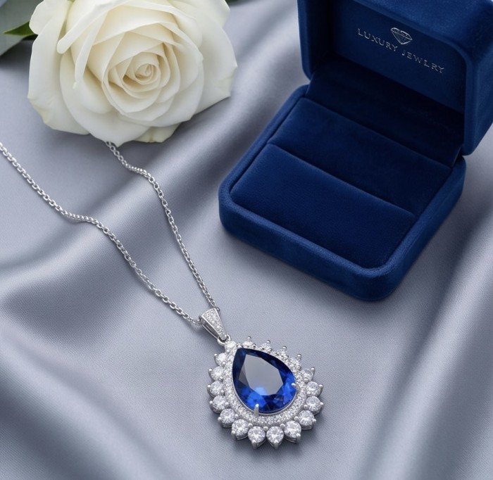 Authentic 14.5 carat Tanzanite rhodium over .925 Sterling Silver handmade necklace - Tanzanite necklace in box, top view with white rose on satin background.