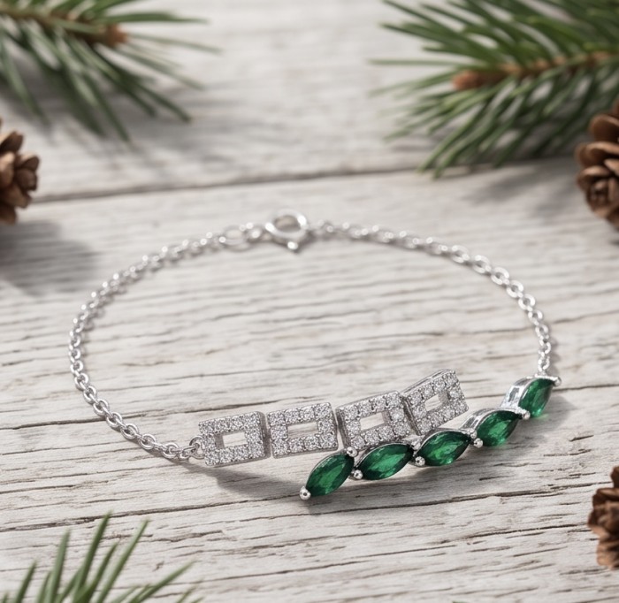 Precious 4.2 carat natural Colombian Emerald rhodium over .925 Sterling Silver handcrafted bracelet - Emerald bracelet on wood with pine needles, top view.