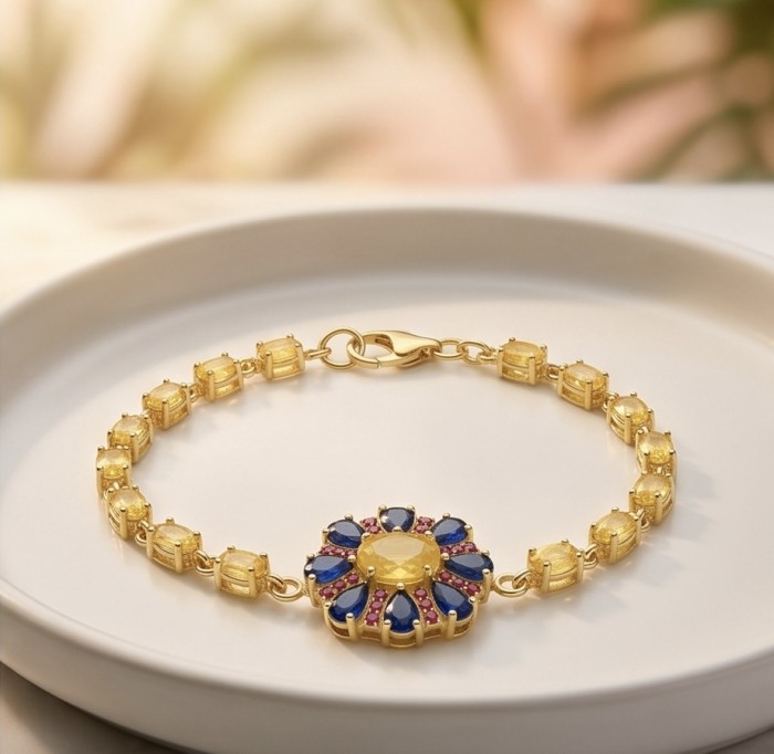 Luxurious 12.5 carat oval cut Yellow Sapphire 18K Gold over .925 Sterling Silver handcrafted Statement Bracelet - Gold bracelet with yellow sapphire and blue gems, displayed on a plate.