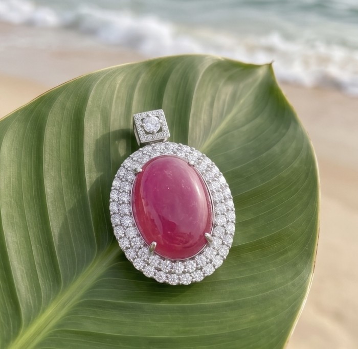 Giovanna 23.2 carat authentic cabochon Mozambique Ruby .925 Sterling Silver handmade Pendant - Close-up of Giovanna Mozambique Ruby pendant on a leaf near the beach.