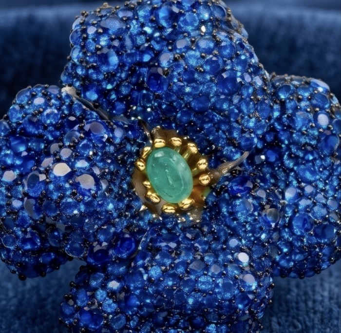 Black Label Collection - Retro Style - Rose Genuine 27.5 carat Sapphire .925 Sterling Silver dipped in rhodium handmade Pendant - Brooch - Close-up of blue gem-encrusted flower jewelry with green gemstone center.