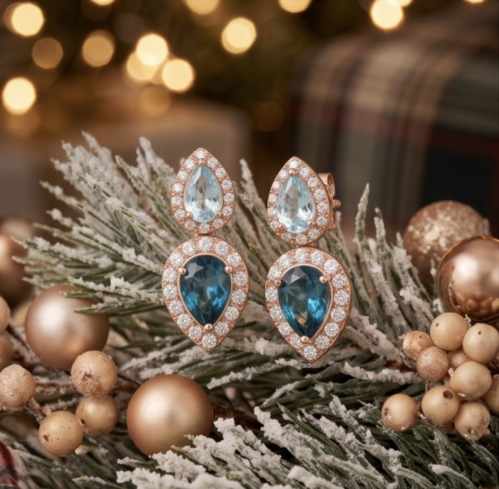 Ocean's Tears 4.5 carat London Blue Topaz 18K Gold over .925 Sterling Silver handcrafted earrings - Earrings among festive decor, front view with blue topaz close-up.