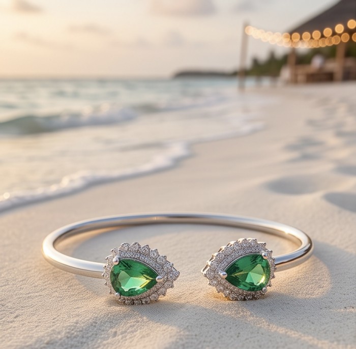 Victoria 8.7 ctw Colombian Emerald rhodium over .925 Sterling Silver handcrafted Statement bracelet - Emerald bracelet with pear-cut stones on sandy beach background.