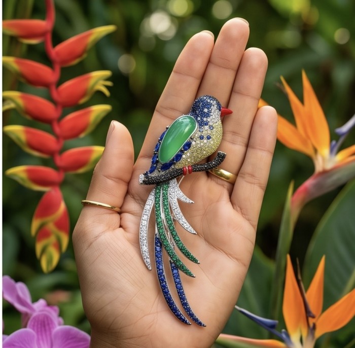 Exotic Parrot - Genuine 18.4 carat Jade from New Zealand .925 Sterling Silver dipped in rhodium handmade Pendant - Brooch - Parrot brooch with jade stone, held in hand, vibrant garden background.