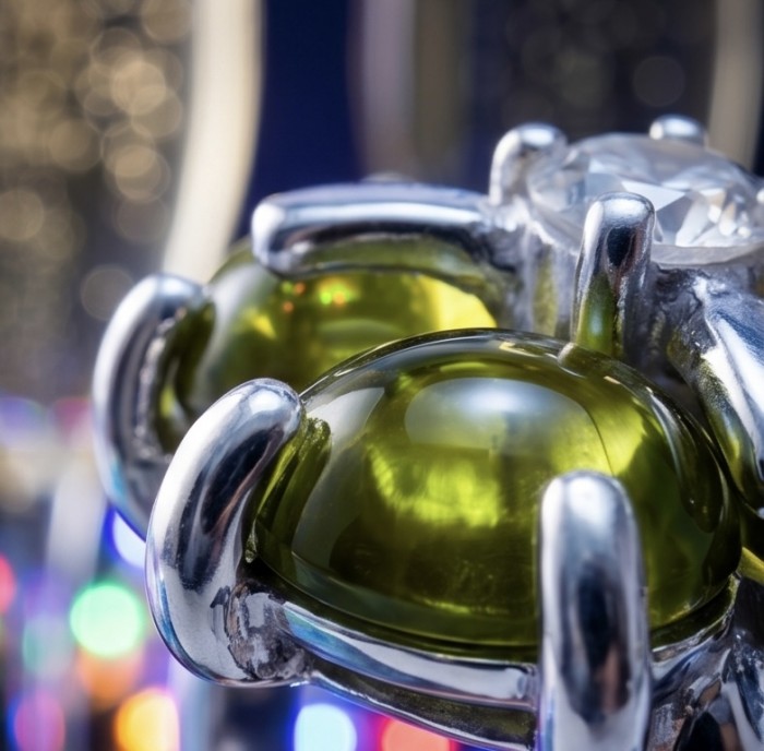 Clover 7.9 carat authentic Himalayan Peridot .925 Sterling Silver Handcrafted Statement Ring size 6 - Close-up of Clover Peridot in sterling silver setting with colorful bokeh.