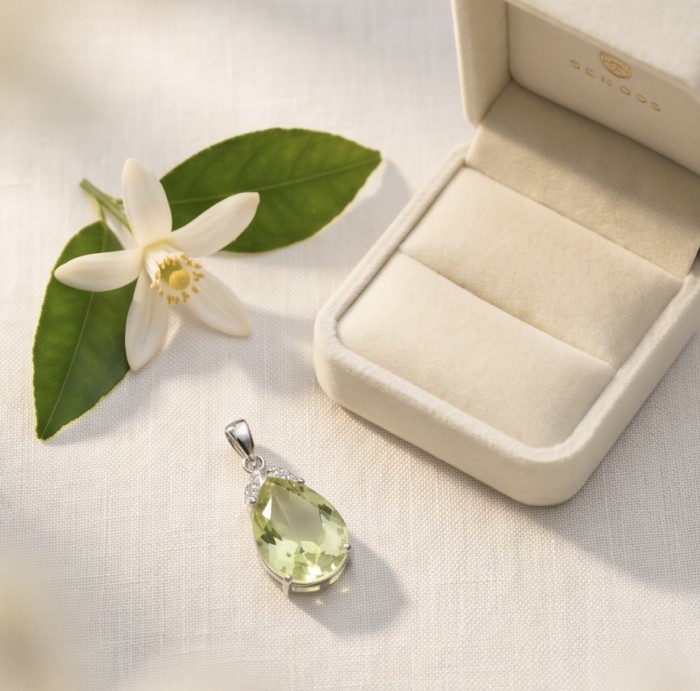 Pear cut 11.3 carat Lemon Quartz rhodium over .925 Sterling Silver handcrafted pendant - Pear cut lemon quartz pendant next to open jewelry box and flower.