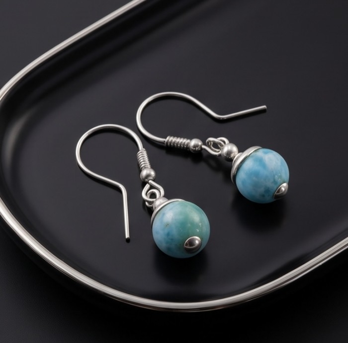 Caribbean Beauty Genuine 8.5 carat Blue Larimar .925 Sterling Silver handmade earrings - Blue Larimar earrings on black tray, silver hooks exposed, side view.