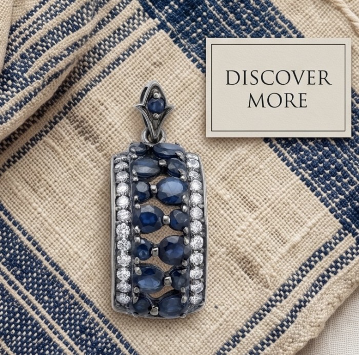 Vintage Beauty 9.7 carat Mozambique Sapphire Black Rhodium over .925 Sterling Silver handcrafted pendant - Pendant with sapphires and diamonds on fabric background, top view.