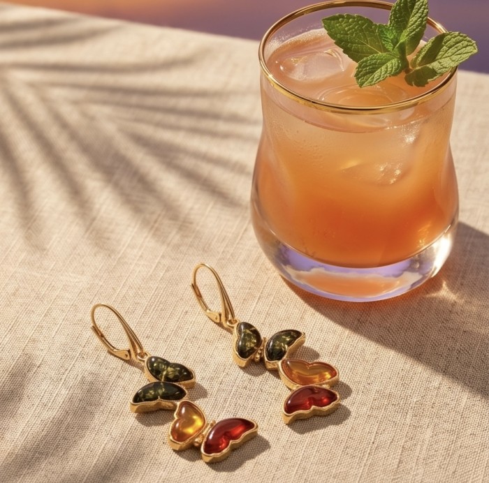 Two Butterflies carved Baltic Polish Amber 18k Gold over .925 Sterling Silver earrings - Butterfly amber earrings with iced drink in soft sunlight.
