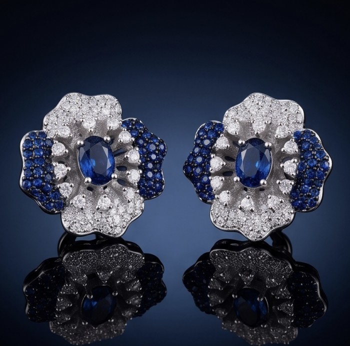 Natural 4.2 carat Mozambique Sapphire .925 Sterling Silver dipped in rhodium Handcrafted Earrings - Front view of sapphire and diamond flower earrings on a reflective surface