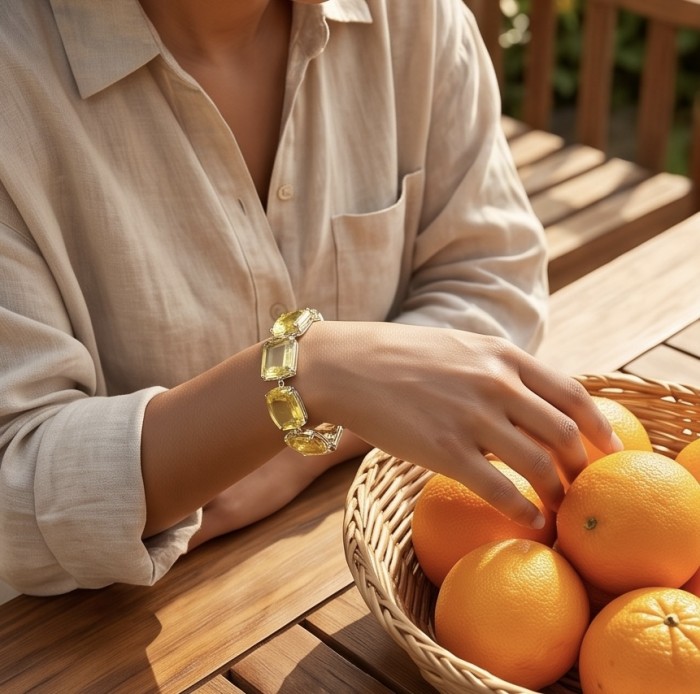 Luxurious Genuine 55.2 CARAT Lemon Quartz .925 Sterling Silver handcrafted Bracelet - Bracelet with lemon quartz stones worn on wrist near basket of oranges.