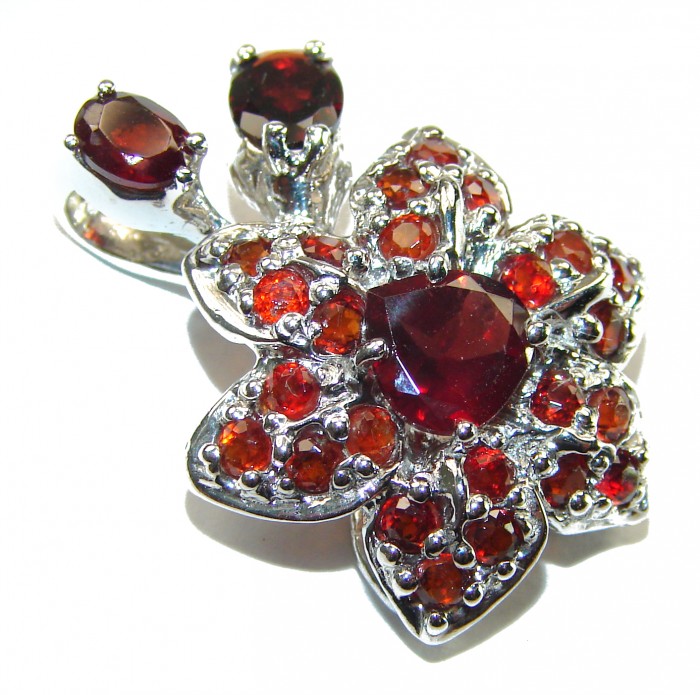 Red Flower Authentic 14.5 carat faceted authentic Australian Garnet .925 Sterling Silver handcrafted Statement Pendant - Close-up of red gemstone flower pendant with metallic setting.