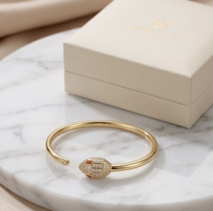 Precious Boa Snake Genuine 0.7 carat orange Sapphire .925 Sterling Silver dipped in 14K Gold handcrafted Bracelet - Gold snake bracelet with sapphire, side view on marble surface