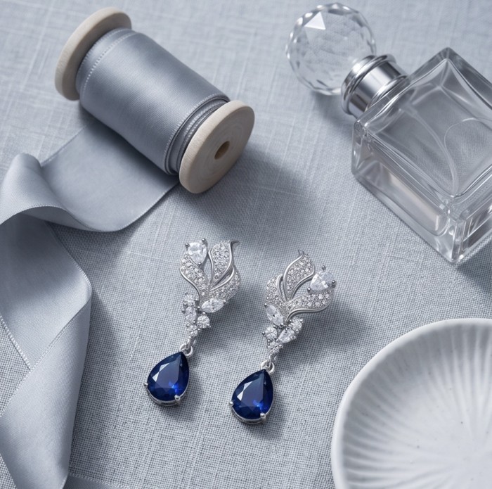 Blue Royalty 3.7 carat Sapphire .925 Sterling Silver handcrafted Statement earrings - Elegant sapphire earrings with ribbon and perfume, top view.
