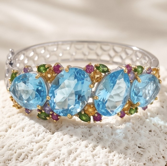 PACIFICA - 25.8 carat Swiss Blue Topaz 10.2 carat Sapphire 18K Rose Gold over .925 Sterling Silver handmade bangle Bracelet - Close-up of a gemstone bracelet with blue topaz and sapphire detailing.