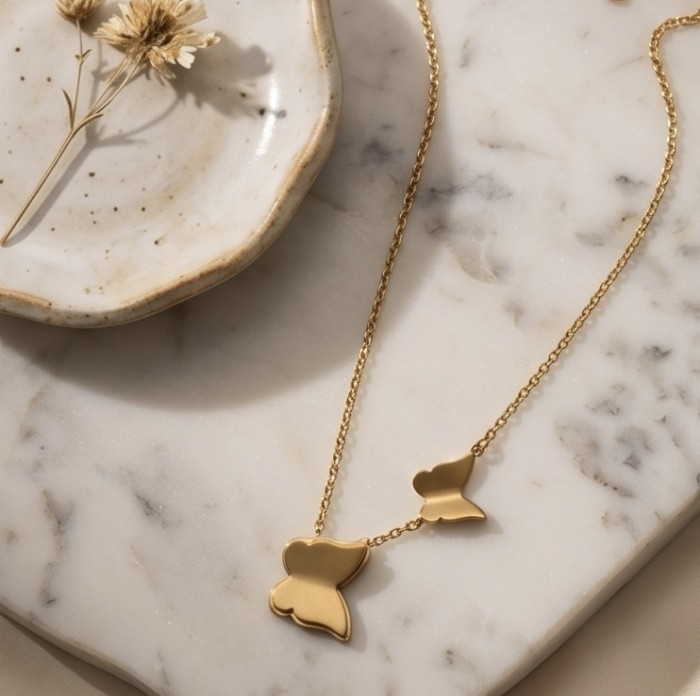 Golden Butterfly 10K Gold over .925 Sterling Silver Italy made necklace - Golden butterfly necklace on marble surface, top view.