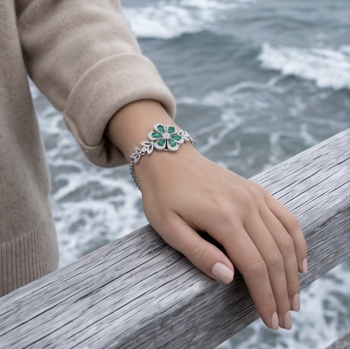 Giovanna - Authentic 7.9 carat Colombian Emerlad .925 Sterling Silver handcrafted Statement bracelet - Bracelet worn on hand, ocean background, emerald stone detail.