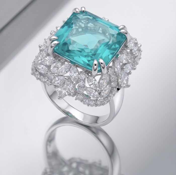 Elizabeth asscher cut 14.8 carat Colombian Emerald 15.3 carat Moissanite .925 Sterling Silver dipped in Rhodium handcrafted Ring size 7 - Close-up of Elizabeth asscher cut Colombian Emerald ring on reflective surface.