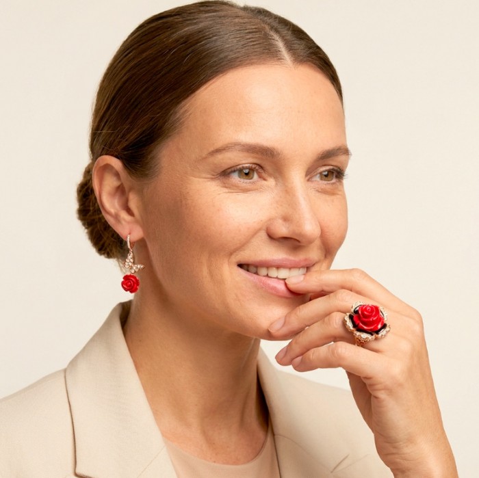 Enchanted Rose Genuine carved Coral 14K Rose Gold over .925 Sterling Silver handcrafted earrings - Woman wearing coral rose earrings and ring, side view, hand to face