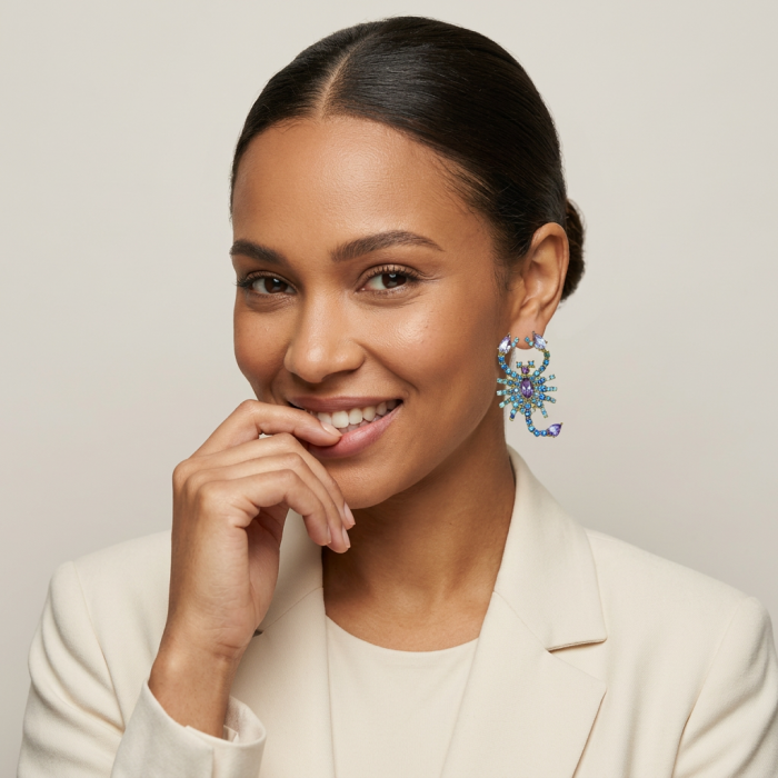 Scorpions authentic 10.2 carat Pink Amethyst Sapphire .925 Sterling Silver Ddipped in 22K Gold handcrafted earrings - Model wearing scorpion-shaped amethyst sapphire earring close-up.