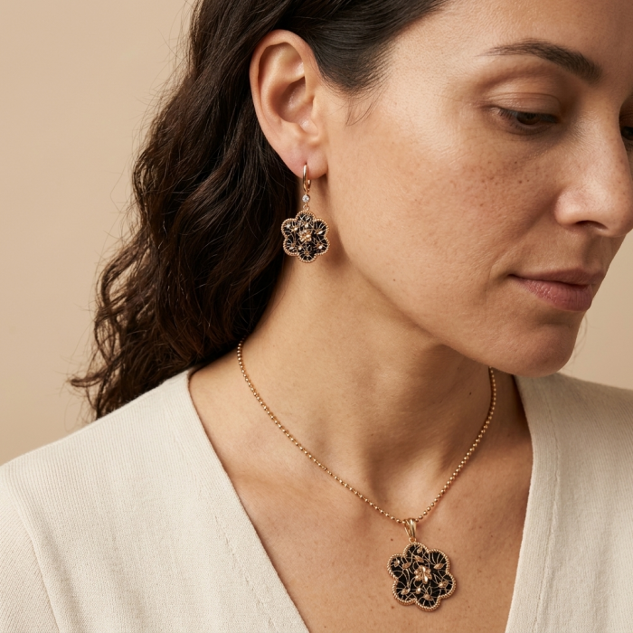 Dubai Style - Golden Flowers black enamel .925 Sterling Silver dipped in 22K Rose Gold handmade Earrings - Side view of woman wearing golden flower pendant and earrings.