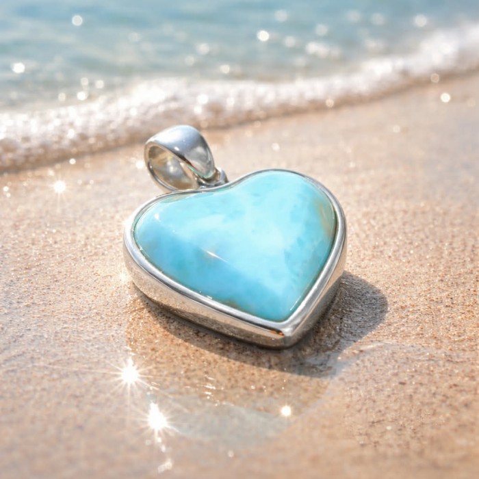 Angel's Heart amazing quality Larimar .925 Sterling Silver handmade pendant - Close-up of heart-shaped Larimar pendant on beach sand.