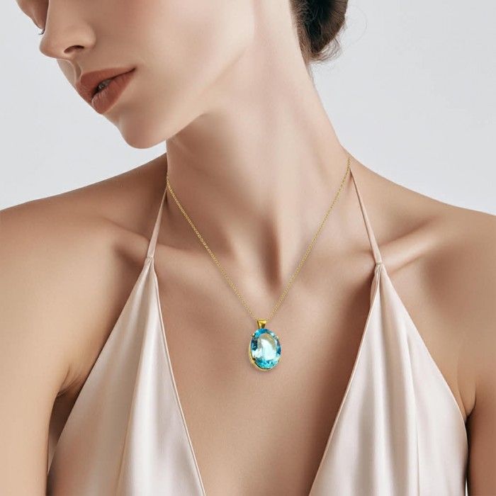 Atlantica oval cut 22.9 carat Swiss Blue Topaz 18K Gold over .925 Sterling Silver Handcrafted Pendant - Swiss Blue Topaz necklace worn on model in 18K gold setting.