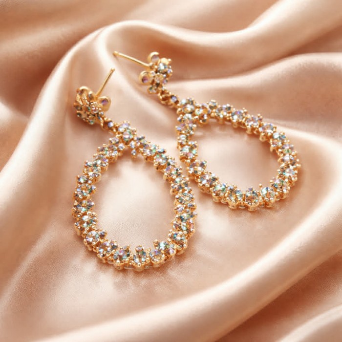 Pure Serenity 8.5 carat genuine Swiss Blue Topaz 18K Gold over .925 Sterling Silver handmade Statement earrings - Gold oval earrings on satin fabric, close-up view.