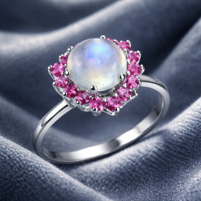 Top quality AAA+ quality Rainbow Moonstone .925 Sterling Silver handmade ring s. 9 - Moonstone ring with pink gems on fabric, top view.