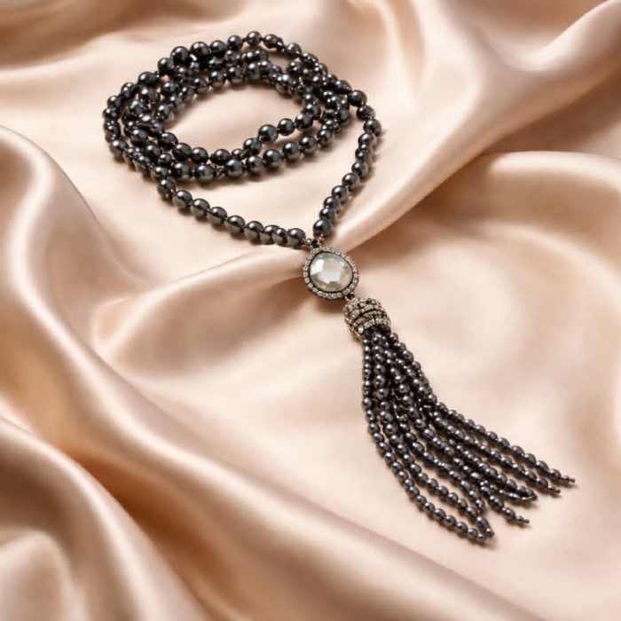 Boho Style Genuine Titanum Crystal .925 Sterling Silver handmade necklace 34 inches long - Boho necklace with tassel on satin fabric, top view.