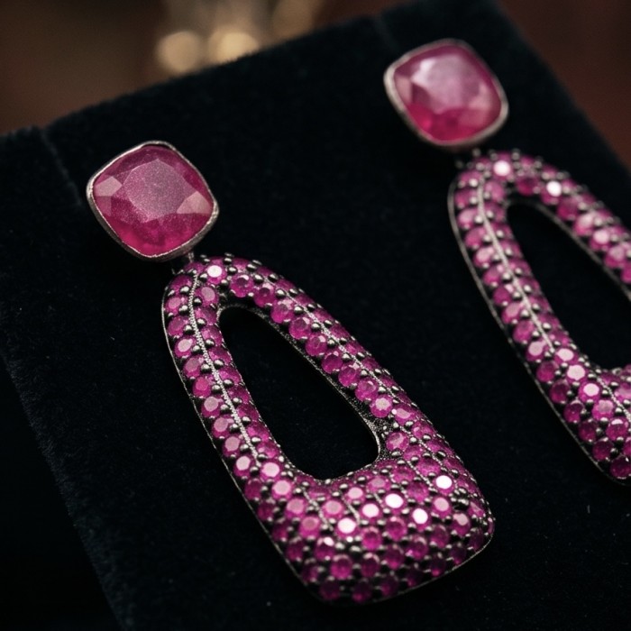 Bella Rossa - 2.5 carat pave Mozambique Ruby .925 Sterling Silver dipped in Rhodium handcrafted earrings - Close-up of Bella Rossa ruby earrings on black velvet display.