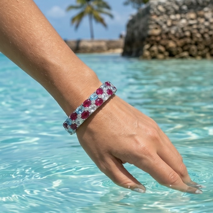 Fiesta Authentic 51.2 carat Morganite Ruby Swiss Blue Topaz .925 Sterling Silver handmade bangle Bracelet - Bracelet worn on hand over water, showcasing rubies and blue topaz.