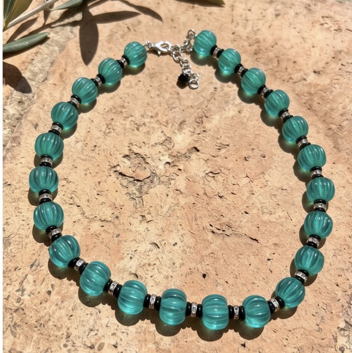 Art Deco - Rio de Janeiro - 52.2 carat carved Apatite .925 Sterling Silver handmade necklace - Close-up of Art Deco necklace with carved apatite beads on stone background.