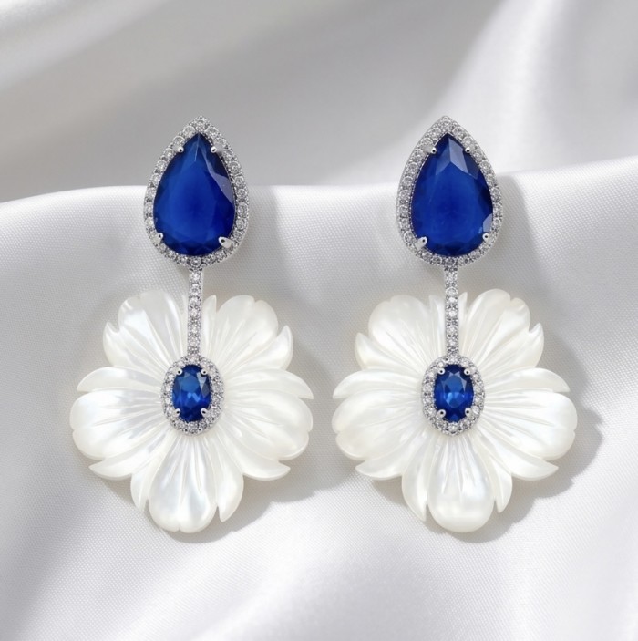 Summer Flowers Blister Pearl Blue Topaz 14K Gold over .925 Sterling Silver handcrafted Earrings - Front view of blue topaz and blister pearl earrings on white fabric.