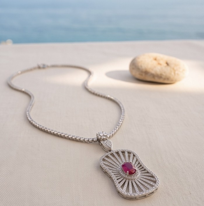 Luxurious 4.8 carat natural Mozambique Ruby .925 Sterling Silver dipped in rhodium Statement Necklace - Necklace with ruby pendant, top view on fabric surface.