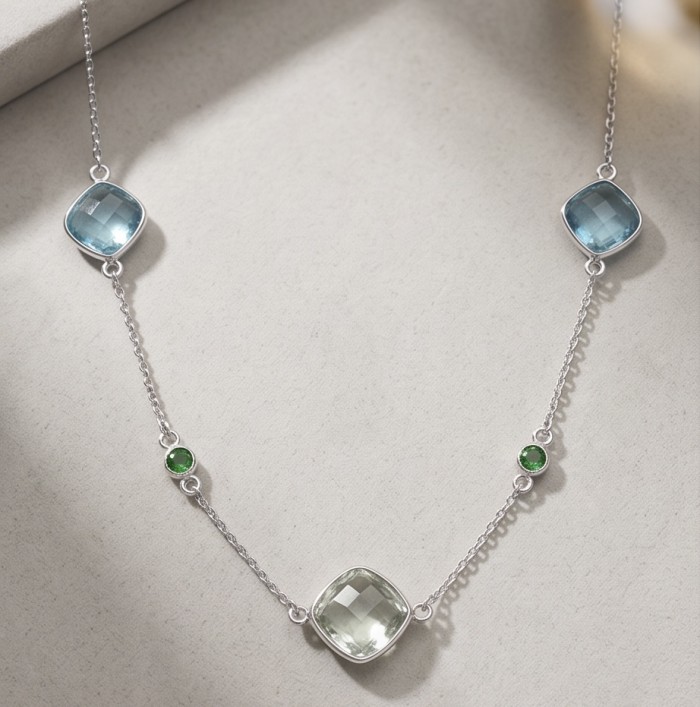 Infinity 18.5 carat Authentic Multigems Rhodium over .925 Sterling Silver handcrafted Statement necklace - Necklace with multigem stones on a flat surface, angled view.