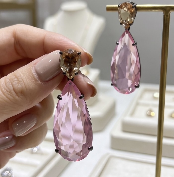 Victoria- authentic pear cut 12.7 carat Pink Topaz .925 Sterling Silver dipped in black rhodium handcrafted Earrings - Close-up of hand holding pear cut pink topaz earrings.