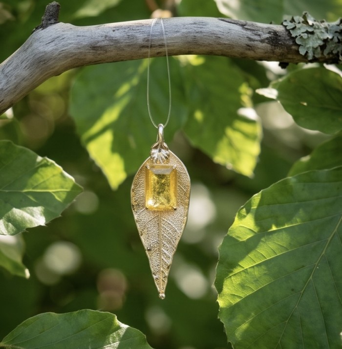 Stylish REAL Leaf dipped in Gold 11.5 carat Garnet .925 Sterling Silver Pendant - Golden leaf pendant with garnet hanging on branch, front view.