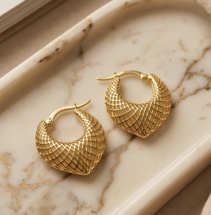 Black Label Collection - Dubai Style - Natural 22K Gold over .925 Sterling Silver handmade earrings - Gold hoop earrings with textured pattern on marble tray, top view.